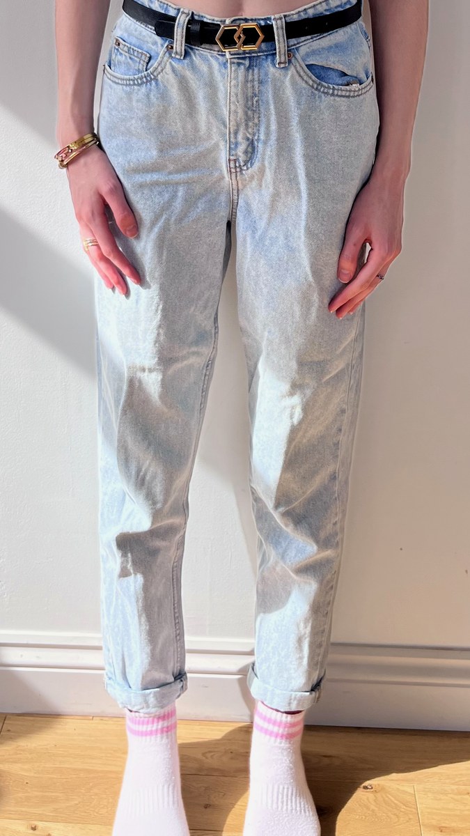 Light wash tapered jeans with rolled cuffs and belt